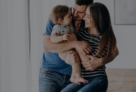 casal segurando o filho pequeno nos braços