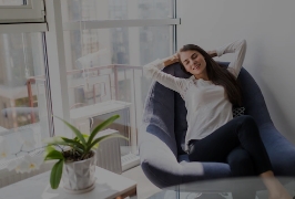 mulher relaxando sentada em um sofá próxima a uma janela